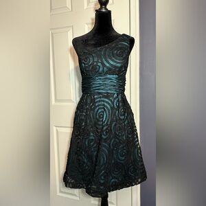 Elegant blue cocktail dress with black lace spiral design
